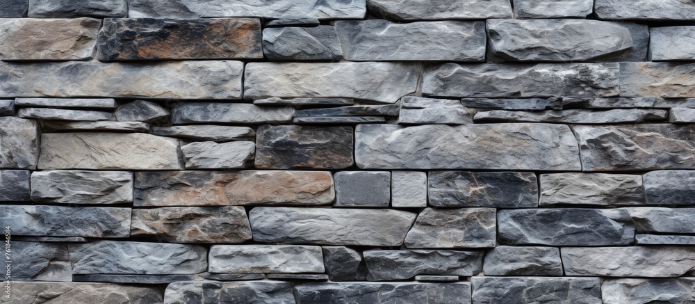 A detailed closeup of a stone wall constructed with rectangular bricks in a patterned design using mortar as a building material A detailed closeup of a stone wall constructed with rectangular bricks in a patterned design using mortar as a building material