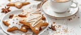 Star-shaped homemade cookies with icing served with coffee on a white surface.