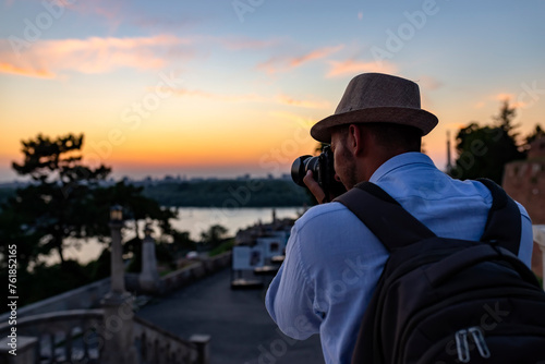 Handsome Young Man with Backpack and Hat on Travel Taking a Photos of the City