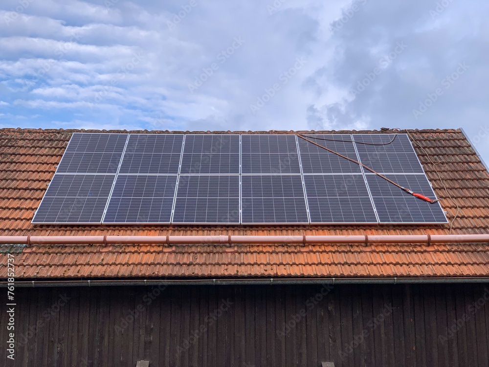 Solar panels on a roof with red tiles