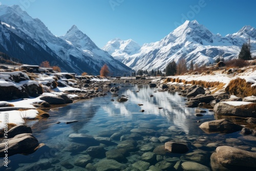 A river flows through a snowy valley, surrounded by snow covered mountains