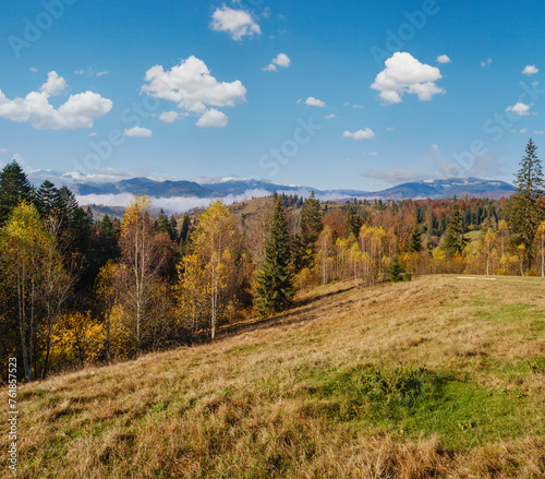 Late autumn mountain morning scene with snow covered tops in far and foggy clouds in valleys. Picturesque traveling, seasonal, nature and countryside beauty concept scene. Carpathians, Ukraine.