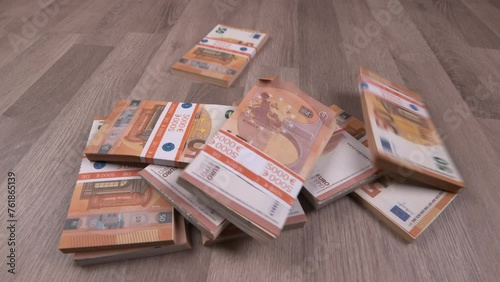 Euro stacks fall onto a wooden floor. Wealth, earning and winning concept.