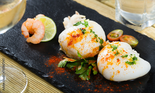 Slate of roasted Cuttlefish and shrimp served with lime and cherry tomatoes photo