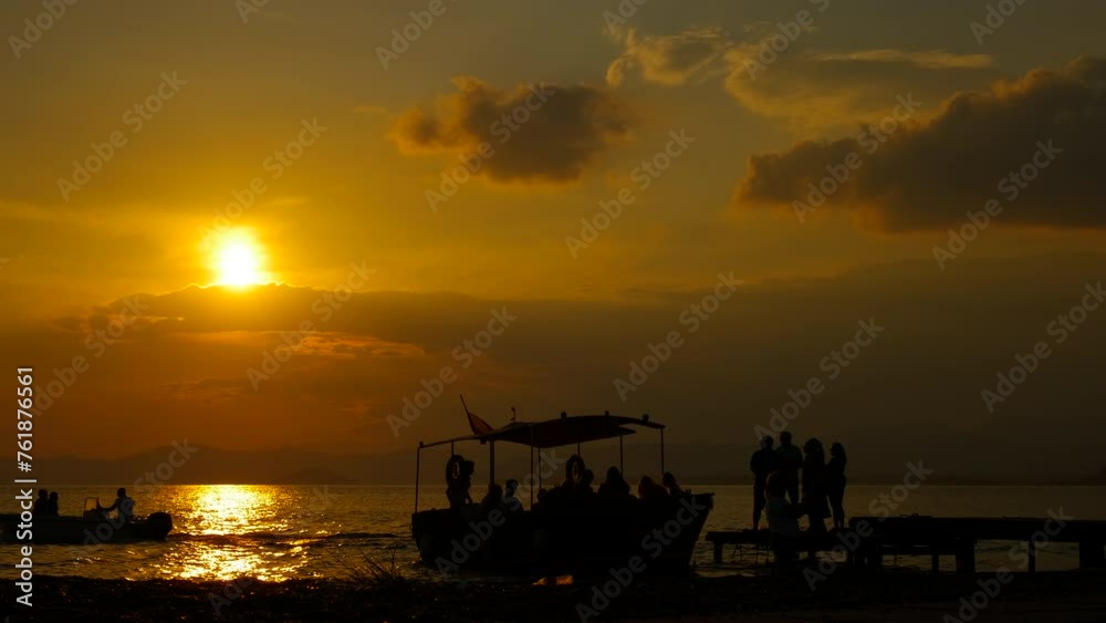 Silhouette of boat against nightfall sky. Silhouette of boat moored by the shore during bright sunset time. Silhouette of boat against nightfall sky. Silhouette of boat moored by the shore during bright sunset time.