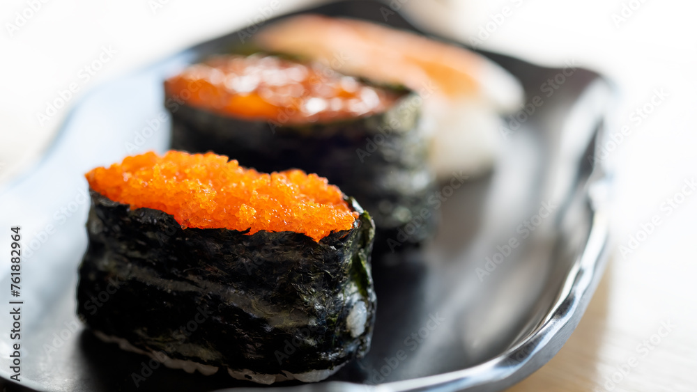 Close up Vibrant Tobiko Gunkan Sushi Focus on a Ceramic Plate Close up Vibrant Tobiko Gunkan Sushi Focus on a Ceramic Plate