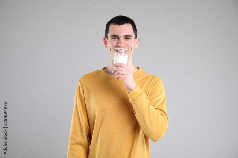 Milk mustache left after dairy product. Man drinking milk on gray background Milk mustache left after dairy product. Man drinking milk on gray background