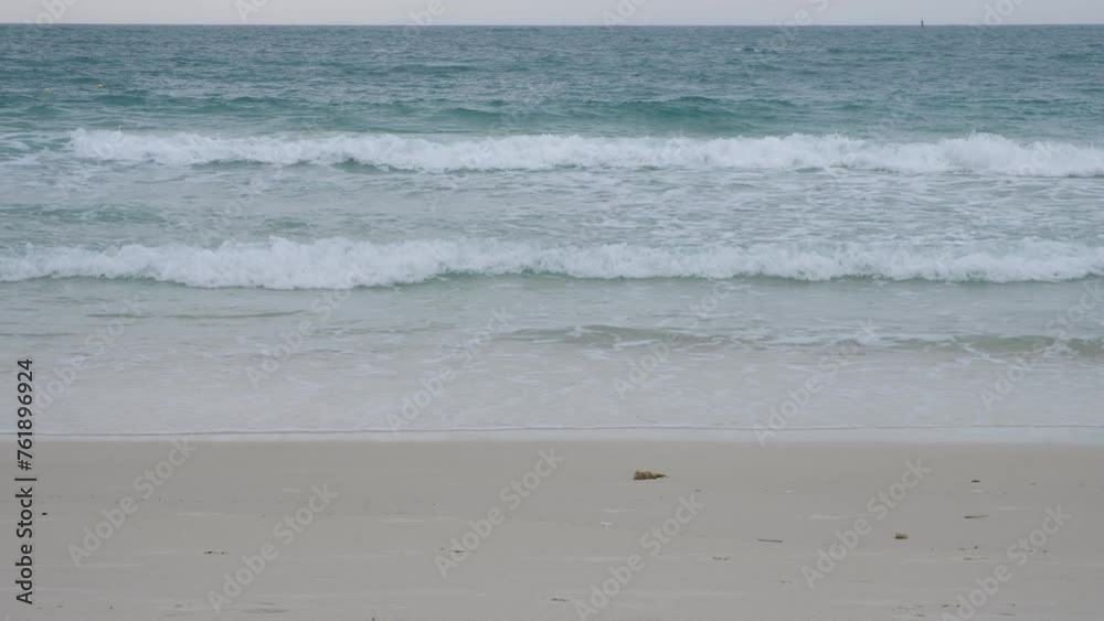 Ocean waves roll onto the brown sand beach. Ocean waves roll onto the brown sand beach.
