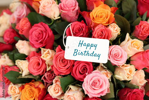 Bouquet of beautiful roses with Happy Birthday card, top view