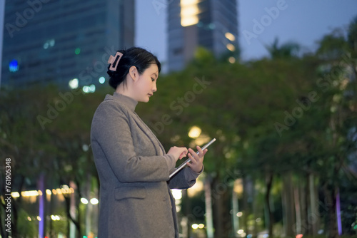Businesswoman Working on Tablet Outdoors at Dusk