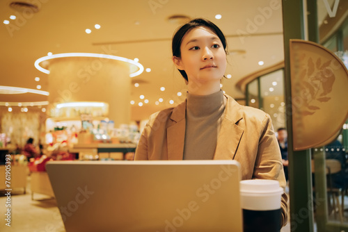 Young Businesswoman Working on Laptop in Cafe