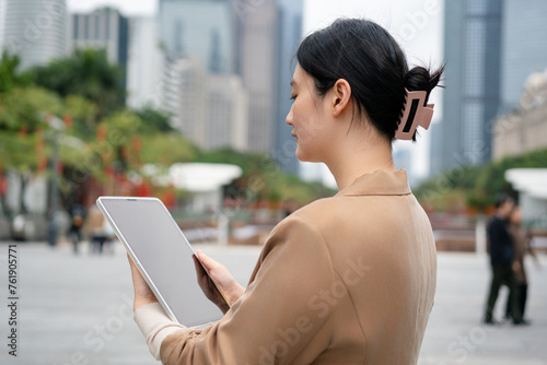 Businesswoman Working on Tablet in Urban Setting © 昊 周