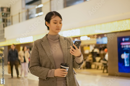 Professional Young Woman Texting on Smartphone Indoors