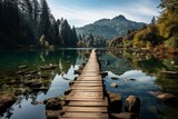 Wooden bridge over water in natural landscape with trees and mountains