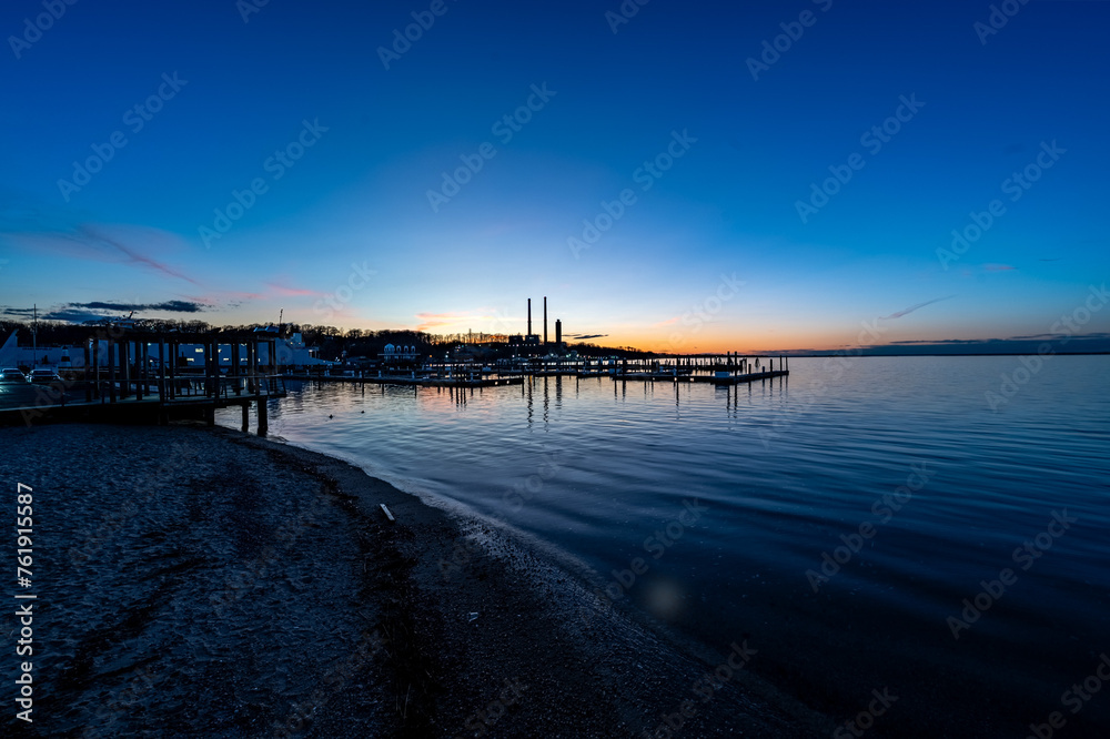 Marvel at the beauty of Port Jefferson Marina at sunset, showcasing the serene marina life with boats docked in calm waters under a breathtaking sky, reflecting the unique charm of Long Island.