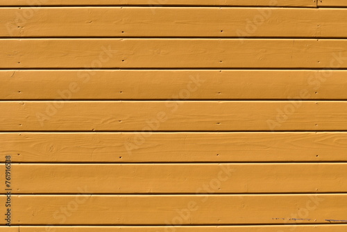 Yellow wooden siding on building.