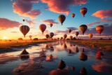 A group of hot air balloons drift peacefully over a river during sunset
