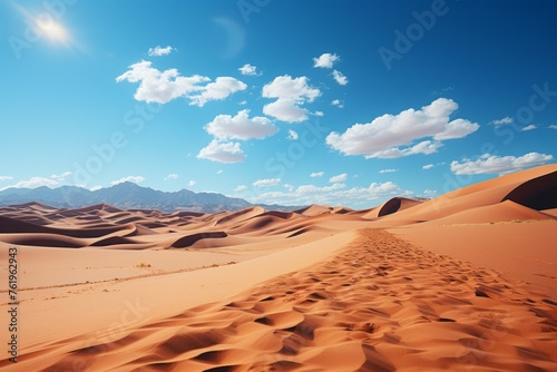 Desert landscape with sand dunes, mountains, and a cloudy sky