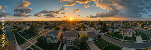 A panoramic view of an idyllic suburban neighborhood at sunset, with multiple single family houses and a wellmaintained street in the center