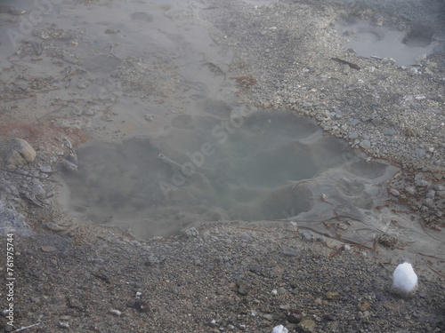 Volcanic landscape with thermal pool and steam rising from hot soil, Baransky volcano on Iturup, Kuril islands photo