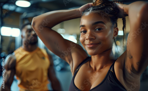 Happy group of friends doing a team huddle in the gym, holding hands and smiling at the camera while working out together