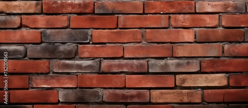 A single red brick standing out on a brick wall