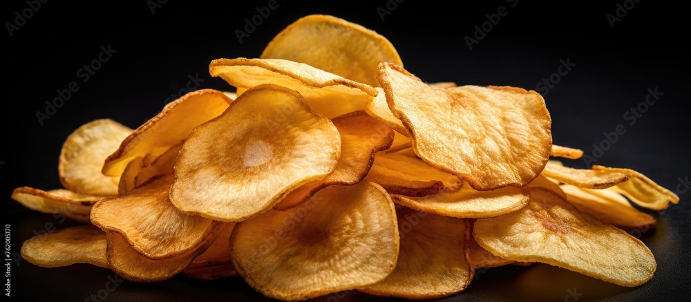 Potato chips pile on black background
