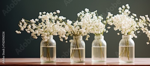 Four vases holding colorful flowers on a wooden table