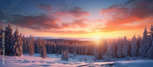 A sunset over snowy mountain trees