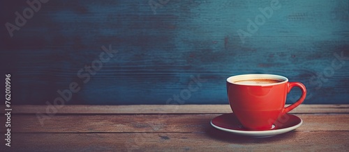 A close up of a red cup of coffee on a saucer
