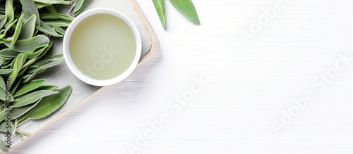 Green tea cup and leaves on white wooden table