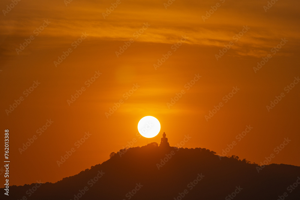 The sun circles in the red sky above Phuket  Big Buddha..Amazing Phuket big Buddha in circle of the sun in red sky..The beauty of the statue fits perfectly with the charming nature. red sky background
