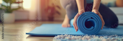 Close up of a woman's hands unrolling a yoga mat on the floor at home,  photo