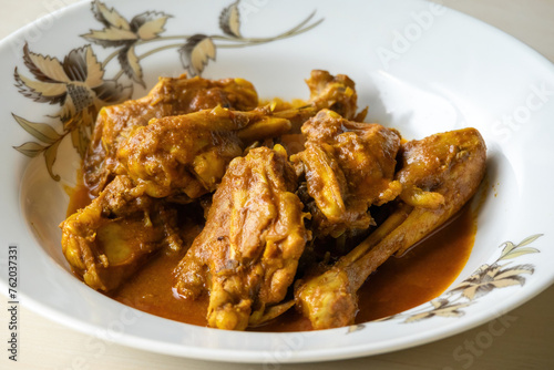 Chicken curry serving on a white plate. Traditional cooked chicken recipe. Spicy Asian food. 