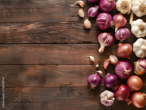 Purple onions and garlic on wooden table with empty space. Spice background.