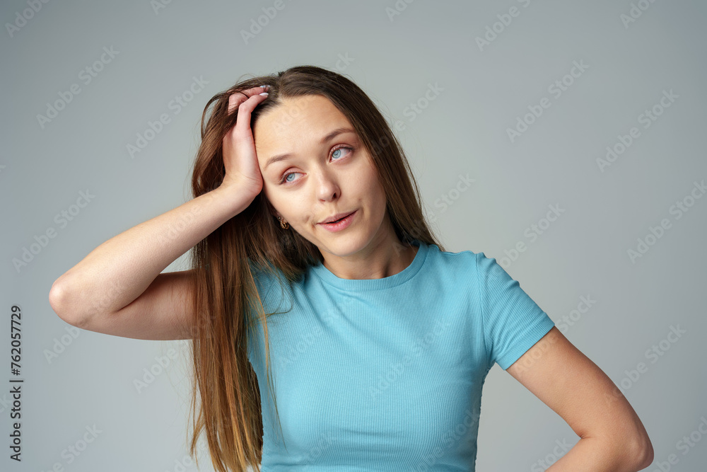 Young woman wearing casual clothes looking tired and bored on gray background