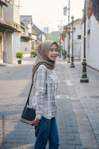 happy asian muslim woman roaming around kota lama or old city area, Semarang, Central Java , Indonesia. Traveling concept