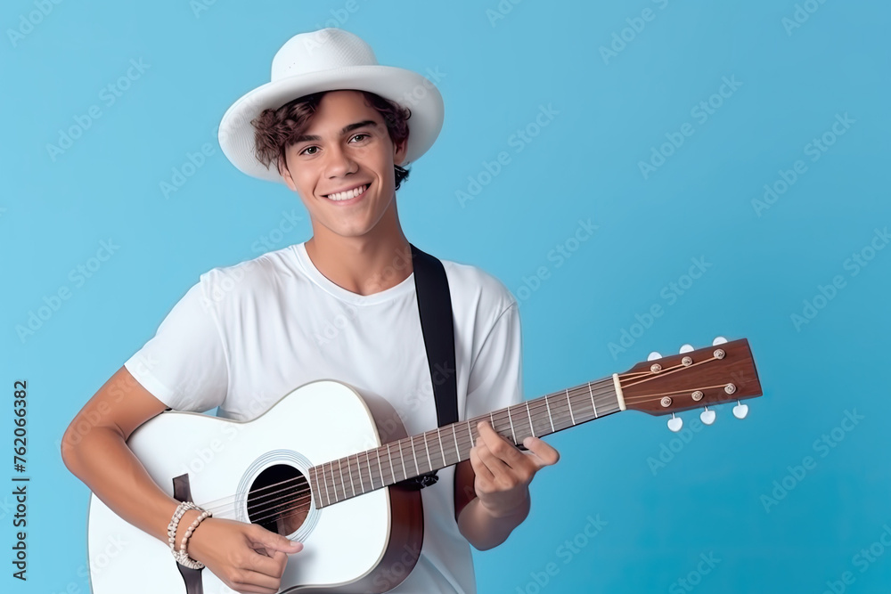 Obraz premium Teenager boy playing the guitar on blue background.