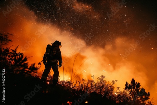 Silhouette of a firefighter with smoke and flames under a starry night rescue.