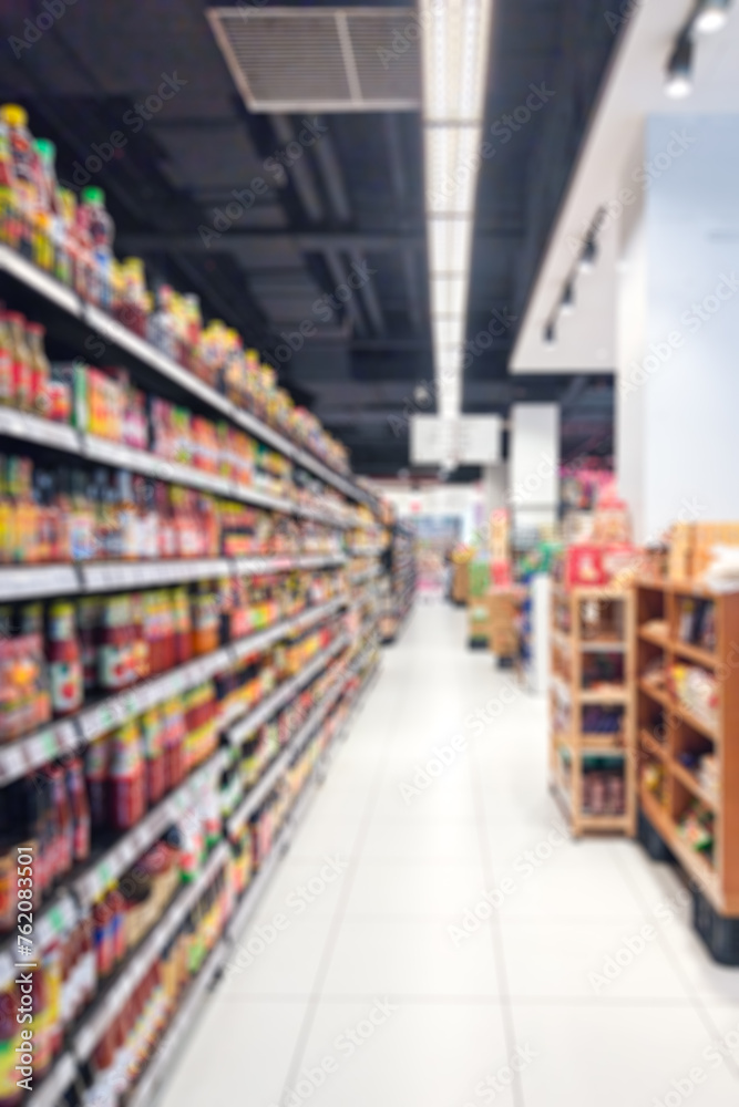 Supermarket aisle, shelves with products. Blurred or defocused for background.