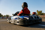 Back view shot of competitive racer driving go-cart sports track