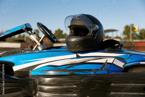 Closeup helmet on go-cart car at automotive speedway stadium photo