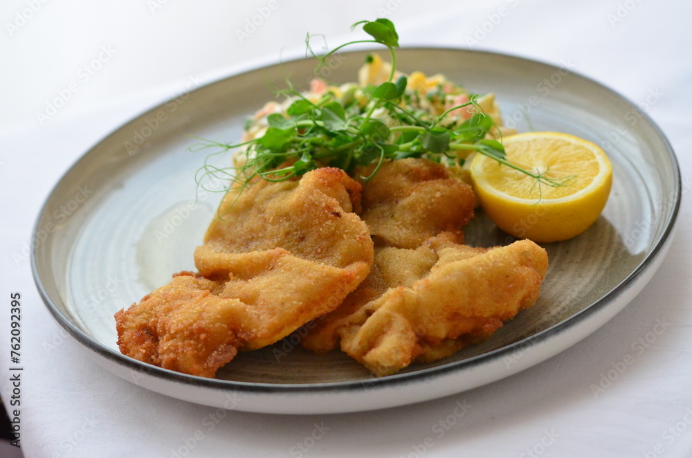 Wiener schnitzel with salad on a restaurant table. Wiener schnitzel with salad on a restaurant table.