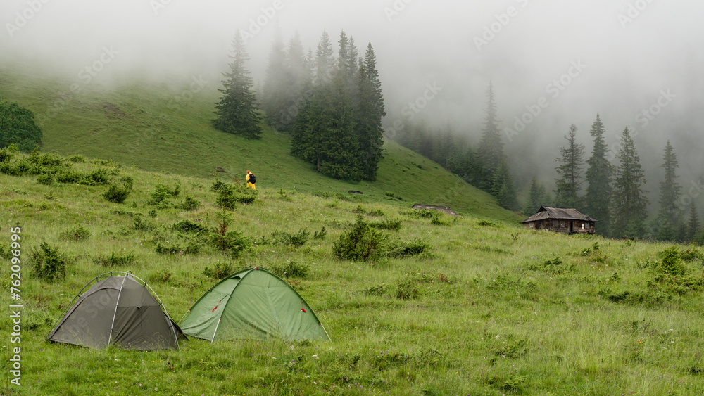 Two tents on a meadow in the mountains, it is raining and foggy. Two tents on a meadow in the mountains, it is raining and foggy.