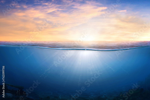 BLUE UNDER WATER waves and bubbles. Orange and golden sunset sky over calm sea with sunlight reflection, Tranquil sea harmony of calm water surface. sunset sky and calm blue ocean.