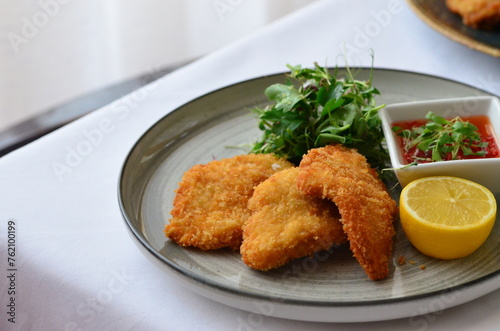 Schnitzel with potatoes and herbs on a plate in a restaurant