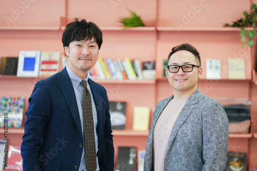 オレンジ背景の書籍と二人の男性