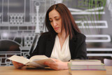  Woman reading book in a library for education, studying, learning and research at school, university campus. Focus, book and student at bookshelf for language learning or philosophy knowledge