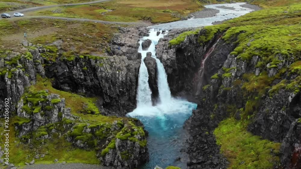 4K drone, aerial cinematic shots of a vibrant green landscape with water cascades down below the cliff that turns into a blue lagoon. 4K drone, aerial cinematic shots of a vibrant green landscape with water cascades down below the cliff that turns into a blue lagoon.