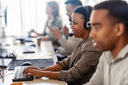 Photography In their office, a multi-ethnic group of IT professionals works together, collab